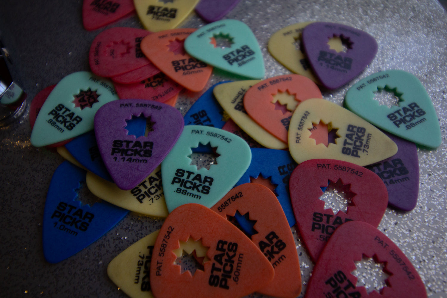 Cleartone Strings guitar picks scattered across a symbol